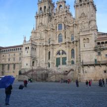 a person with a blue umbrella standing in front of a building