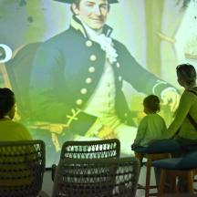 a group of people sitting in chairs in front of a mural