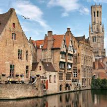 a group of buildings next to a river with a clock tower