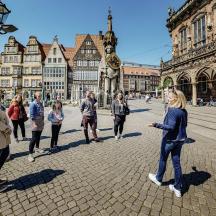 un gruppo di persone in piedi su una strada di una città
