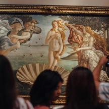 people taking pictures of a painting at the louvre