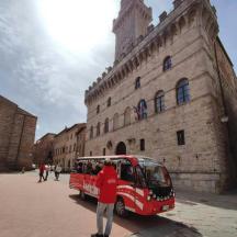 a man standing next to a red bus in front of a building
