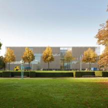 a large building with trees in front of a park