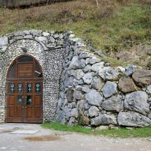 un mur de pedra amb una porta de fusta i una tanca de pedra