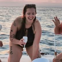 three women in bathing suits on a boat on the beach