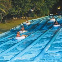 eine Reihe von Menschen, die in einem Wasserpark auf Schläuchen fahren