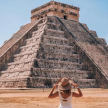 a woman standing in front of a pyramid