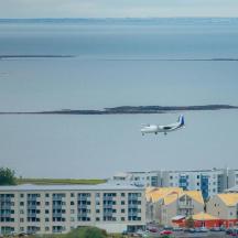 a small plane flying over a city with buildings