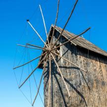 an old wooden windmill against a blue sky