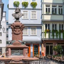 eine Statue mitten in einer Straße mit Gebäuden