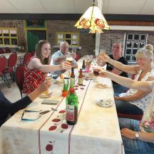 a group of people sitting around a table drinking wine