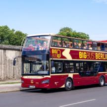 czerwony piętrowy autobus jadący ulicą