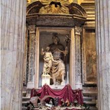 a large statue in a building with a red curtain
