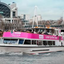 a pink boat in the water with people on it