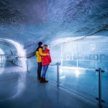a couple standing inside of a ice cave