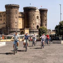 a group of people riding bikes in front of a castle