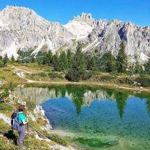 a person with a backpack standing next to a lake