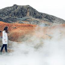 a woman walking in front of a mountain