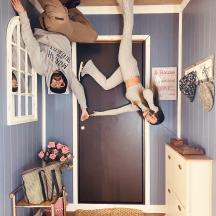 two people laying on the ceiling of a room