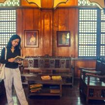 a woman standing in a room reading a book