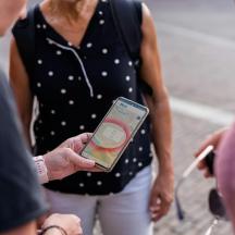 μια γυναίκα που κρατάει ένα κινητό τηλέφωνο στο χέρι της