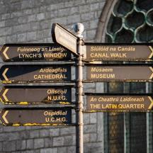 a pole with street signs in front of a building
