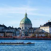 a boat in the water in front of a city
