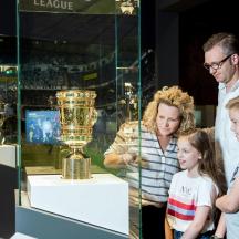 eine Gruppe von Menschen, die eine Trophäe in einer Vitrine betrachten