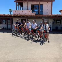 eine Gruppe von Menschen, die vor einem Gebäude Fahrrad fahren