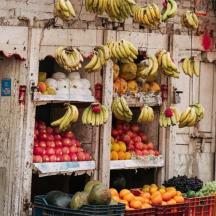 una parada de fruita amb plàtans i altres fruites i verdures