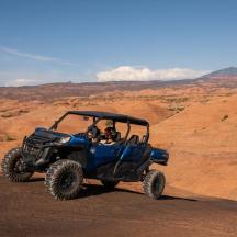 ein blaues ATV fährt auf einer unbefestigten Straße