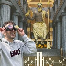 un uomo che guarda attraverso un binocolo davanti a una statua