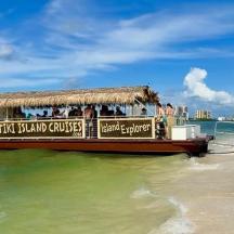 a tour boat on the water on a beach