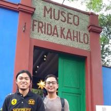 Kaksi miestä seisoo mietteliään Frida Kahlo -kyltin edessä