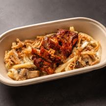 a bowl of pasta with meat and sauce on a table