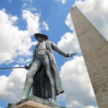 a statue of a man with a spear in front of a tower