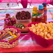 un tavolo con due cestini di popcorn e snack