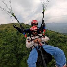 two people are zip lining on a parachute
