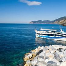 una barca a l'aigua al costat d'una costa rocosa