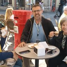 a man and two women sitting at a table with a cake