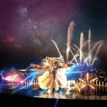 a woman is dancing in front of a stage with fireworks
