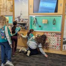 eine Gruppe von Kindern, die sich eine Ausstellung in einem Museum ansehen