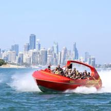 a group of people riding on a red boat in the water