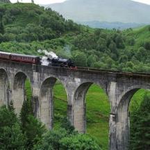 a train on a bridge over a mountain
