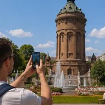 a man taking a picture of a fountain and a tower