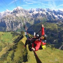 zwei Personen mit einem Fallschirm in den Bergen