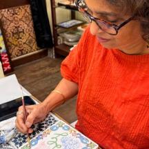 una dona tallant un tros de paper amb tisores