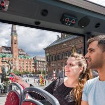 a group of people sitting on a bus in a city