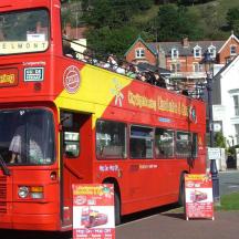 a red double decker bus driving down a street