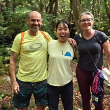a man and two women standing in the woods